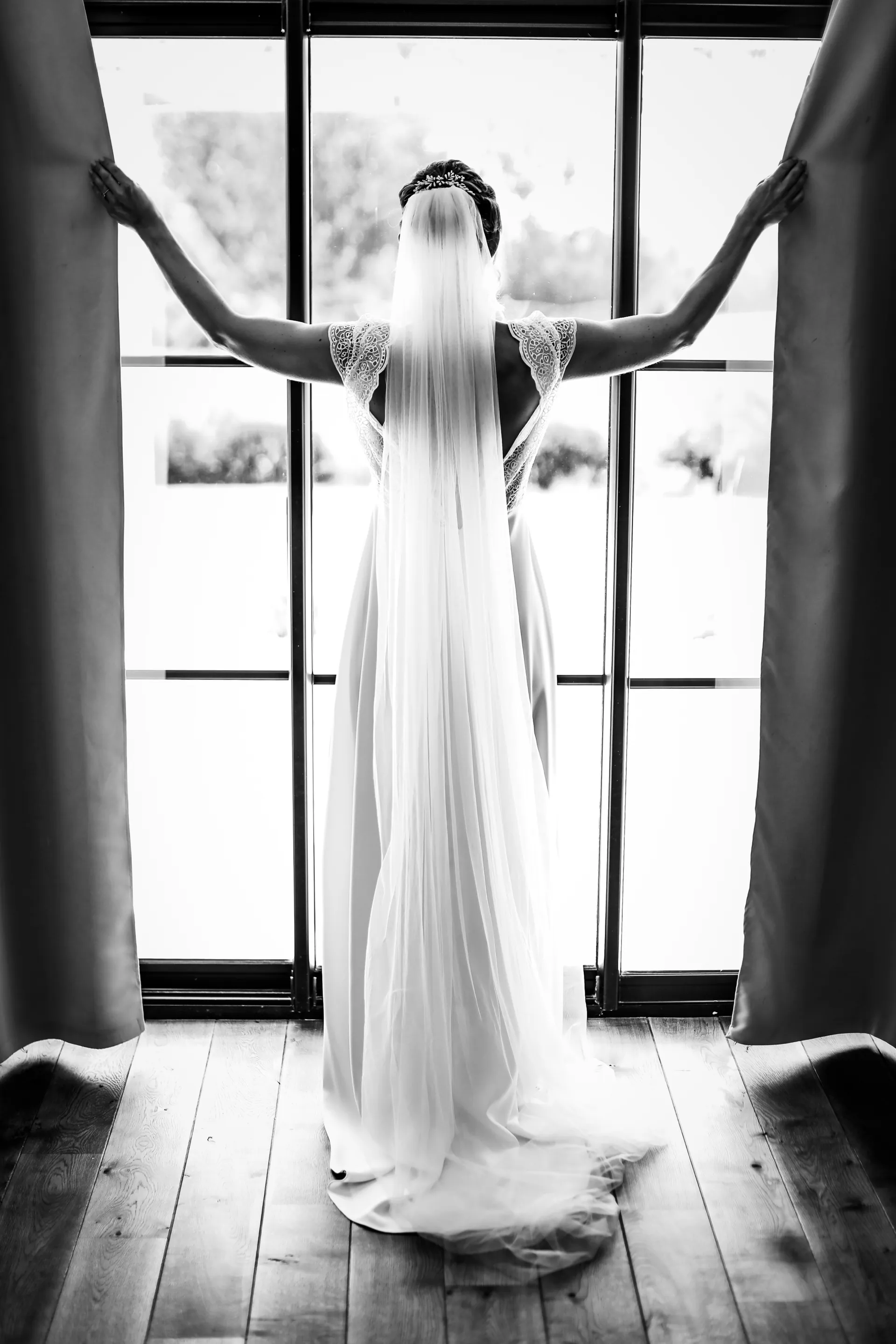 Aurélie de dos à la fenêtre, son long voile, en noir et blanc