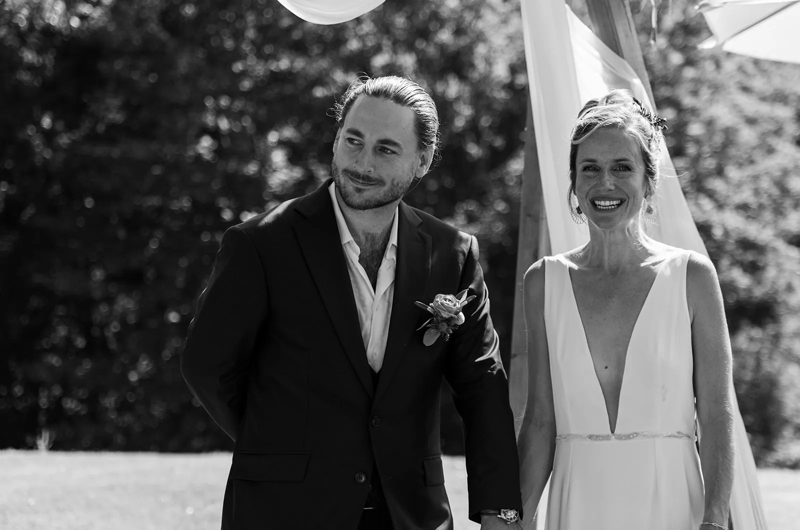 Caroline et son mari côte à côte, en noir et blanc : robe à décolleté V profond et fine ceinture