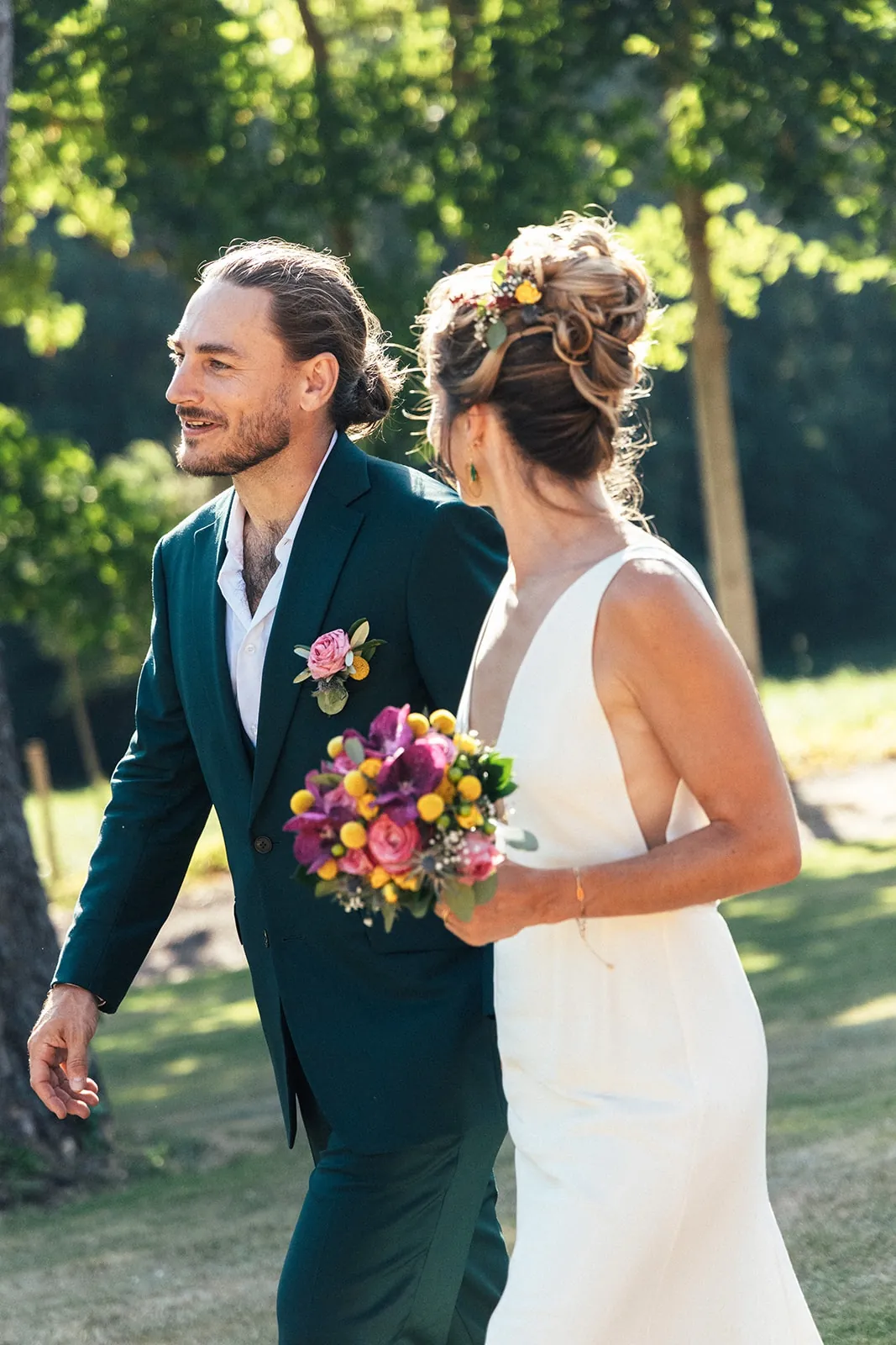 Caroline et son mari, bouquet coloré à la main : le décolleté V profond et le dos nu de la robe