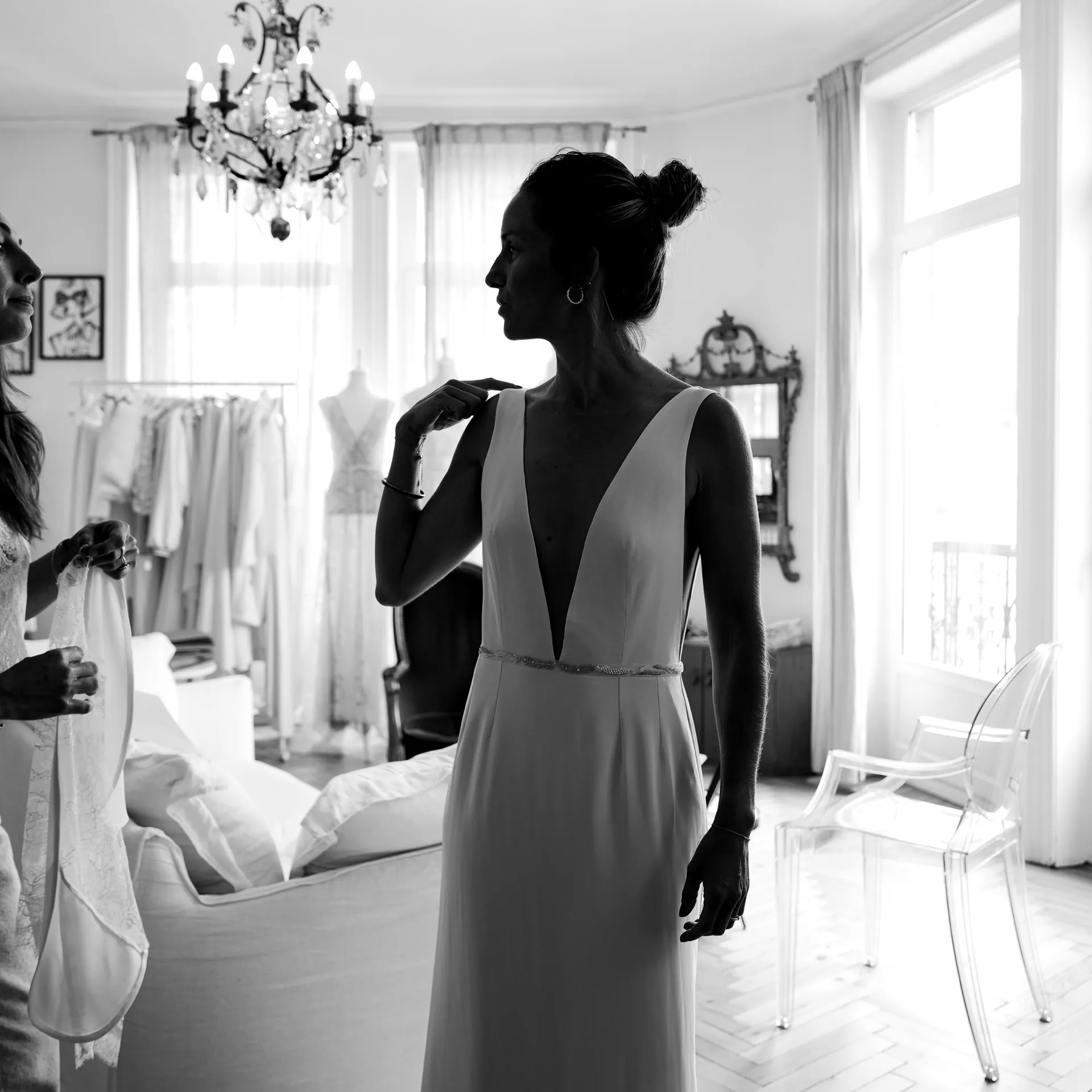 Caroline de profil dans la robe à décolleté V profond et fine ceinture, en noir et blanc