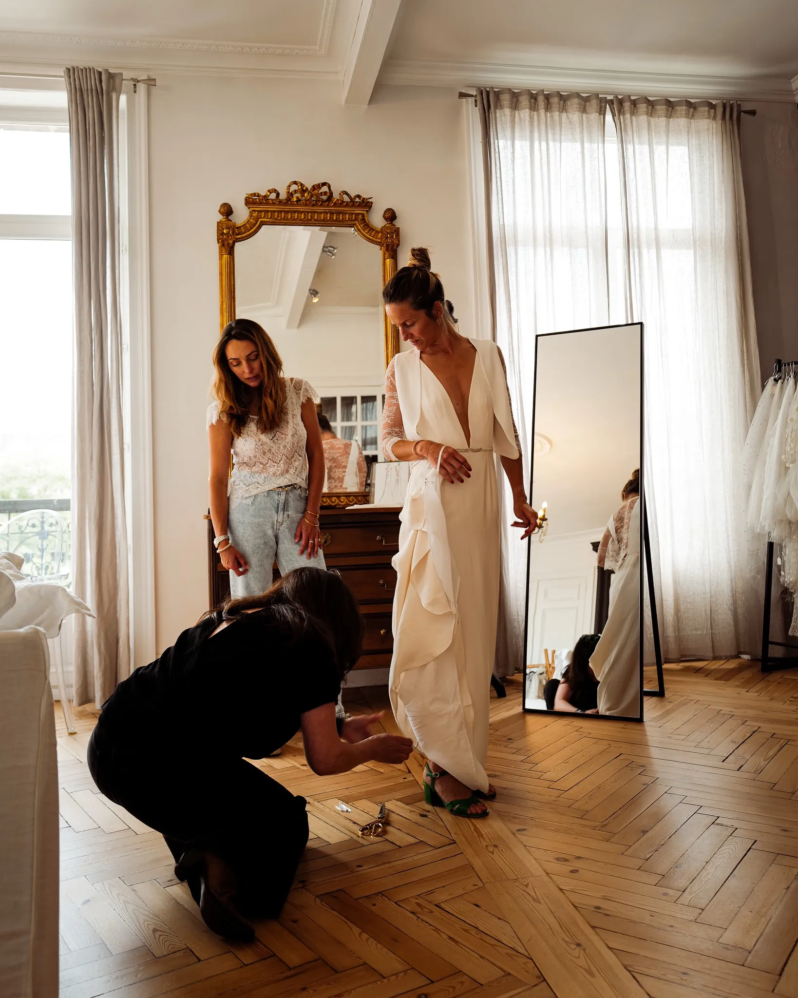 Ajustement de l'ourlet de la robe, sous le gilet à manches en dentelle, au showroom Elsa Barois