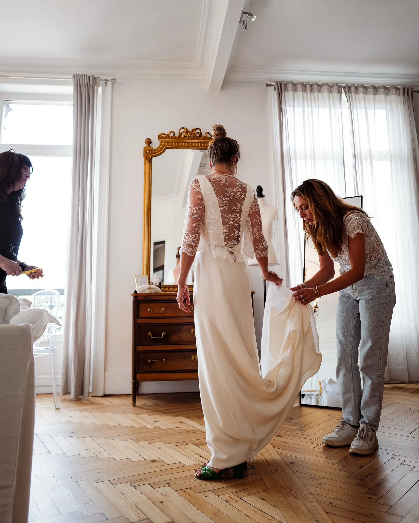 Le gilet en dentelle de Calais vu de dos, la traîne soutenue pendant l'essayage