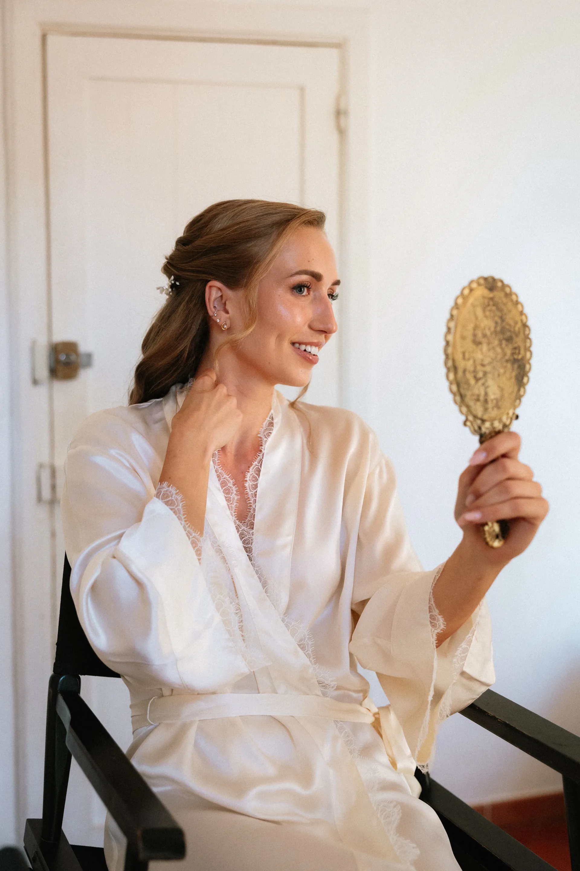 Eugénie, en peignoir de soie ivoire, un miroir à main doré, avant la cérémonie