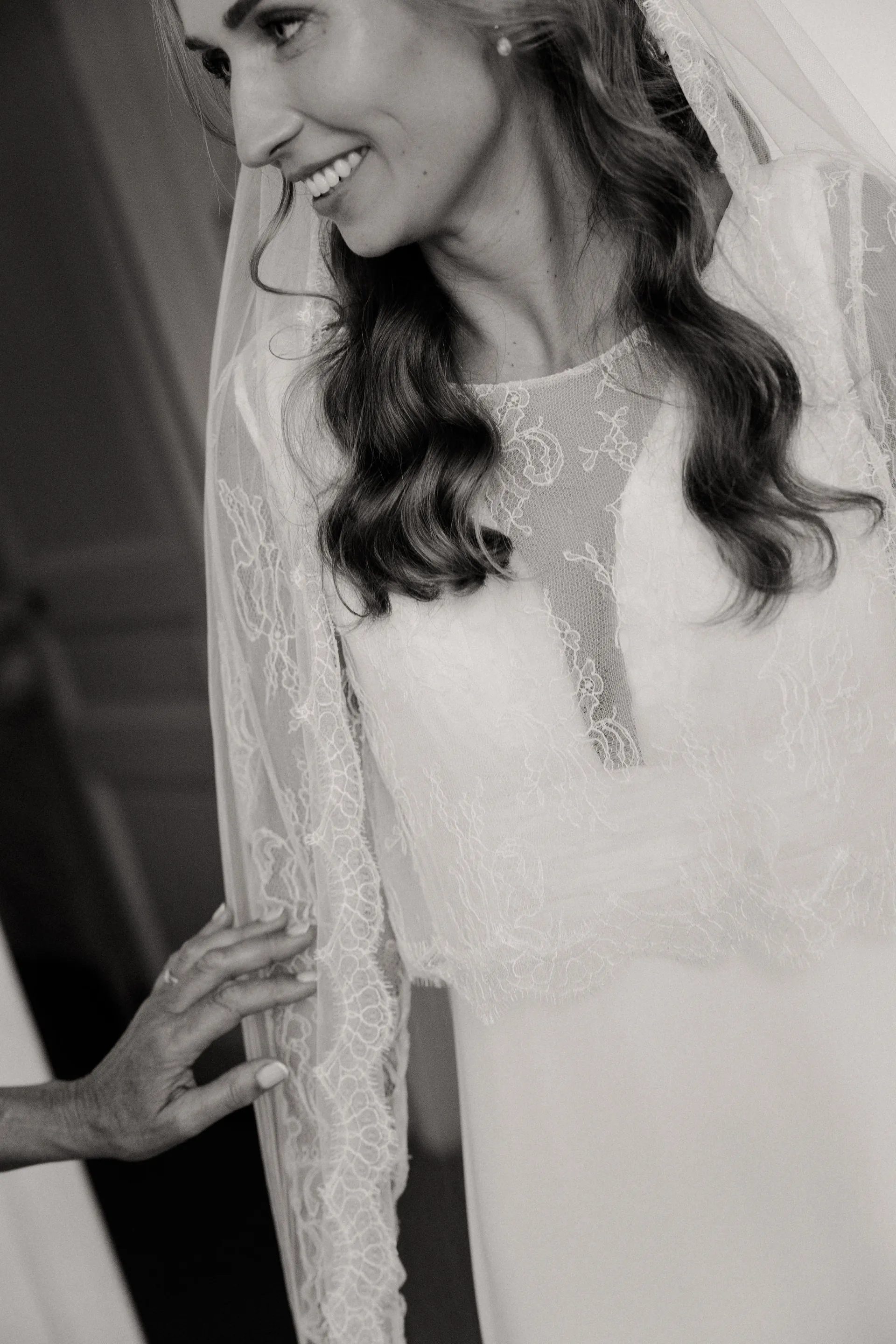 Eugénie sourit, son voile et son top en dentelle, en noir et blanc