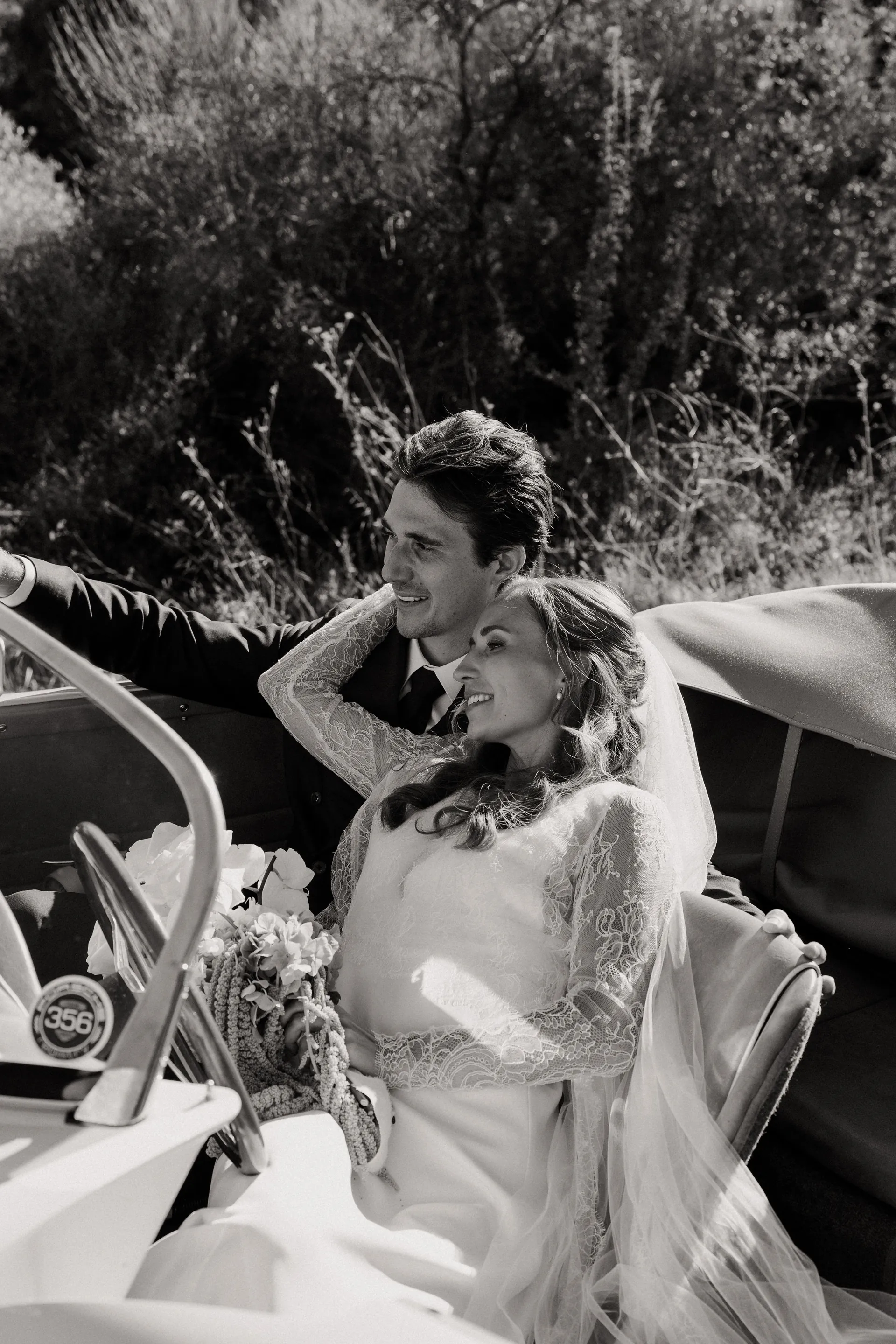 Eugénie et son mari à bord d'une voiture ancienne décapotable, en noir et blanc