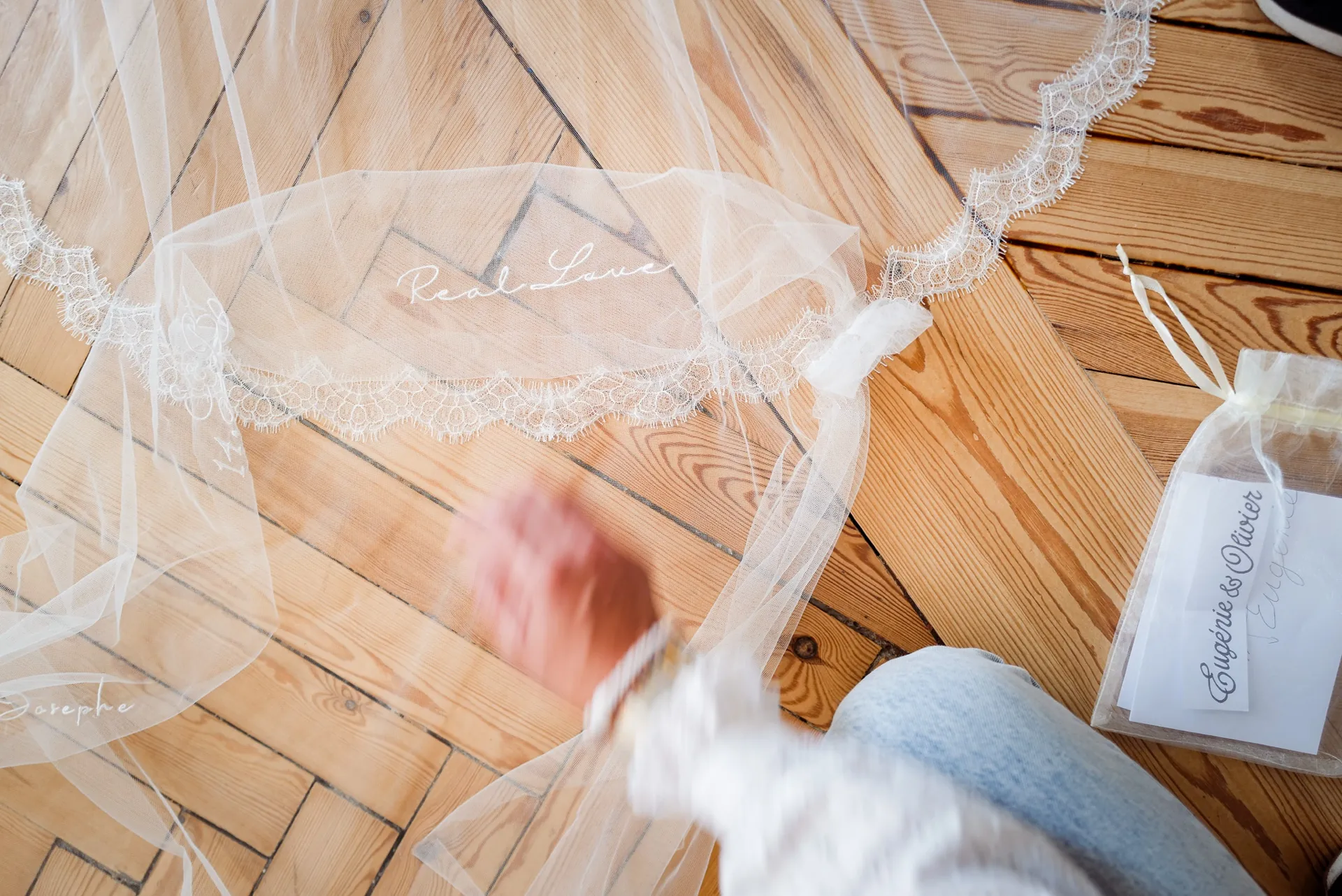Le voile bordé de dentelle, brodé de leurs prénoms, déplié sur le parquet du showroom