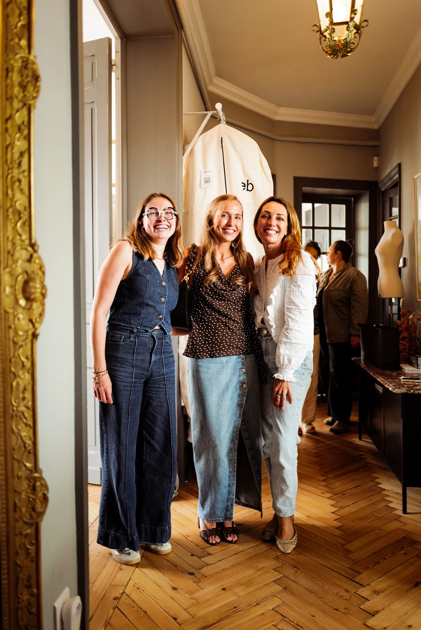 Trois femmes souriantes dans le couloir du showroom Elsa Barois, à la fin du dernier essayage