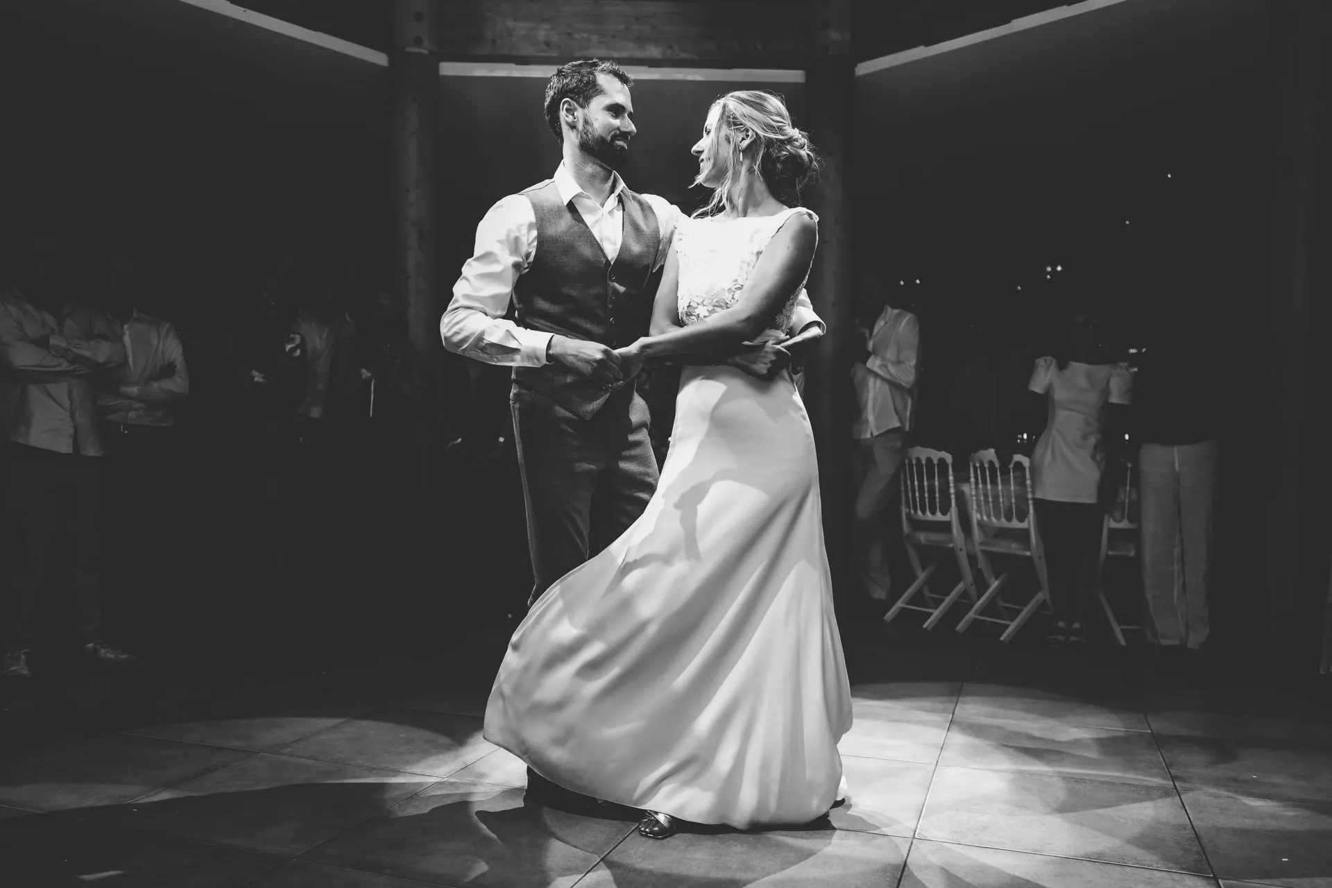 Lola et son mari dansent, la jupe de la robe LIYA en mouvement, en noir et blanc