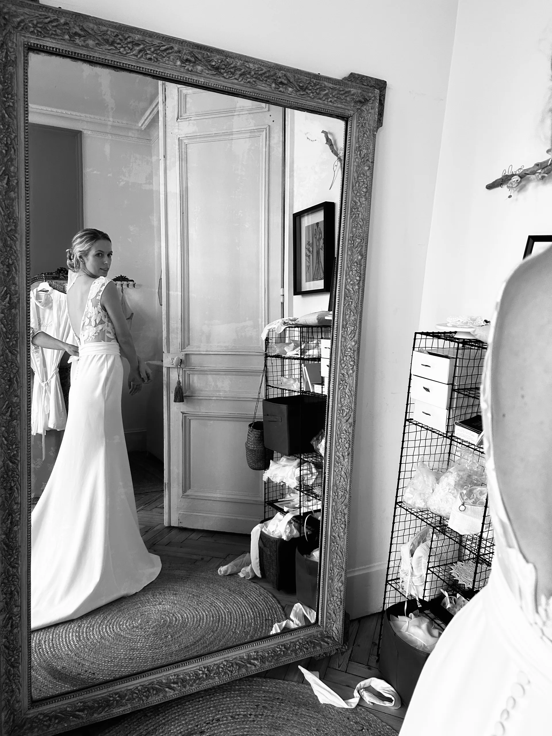 Essayage de Lola devant le grand miroir du showroom Elsa Barois, en noir et blanc