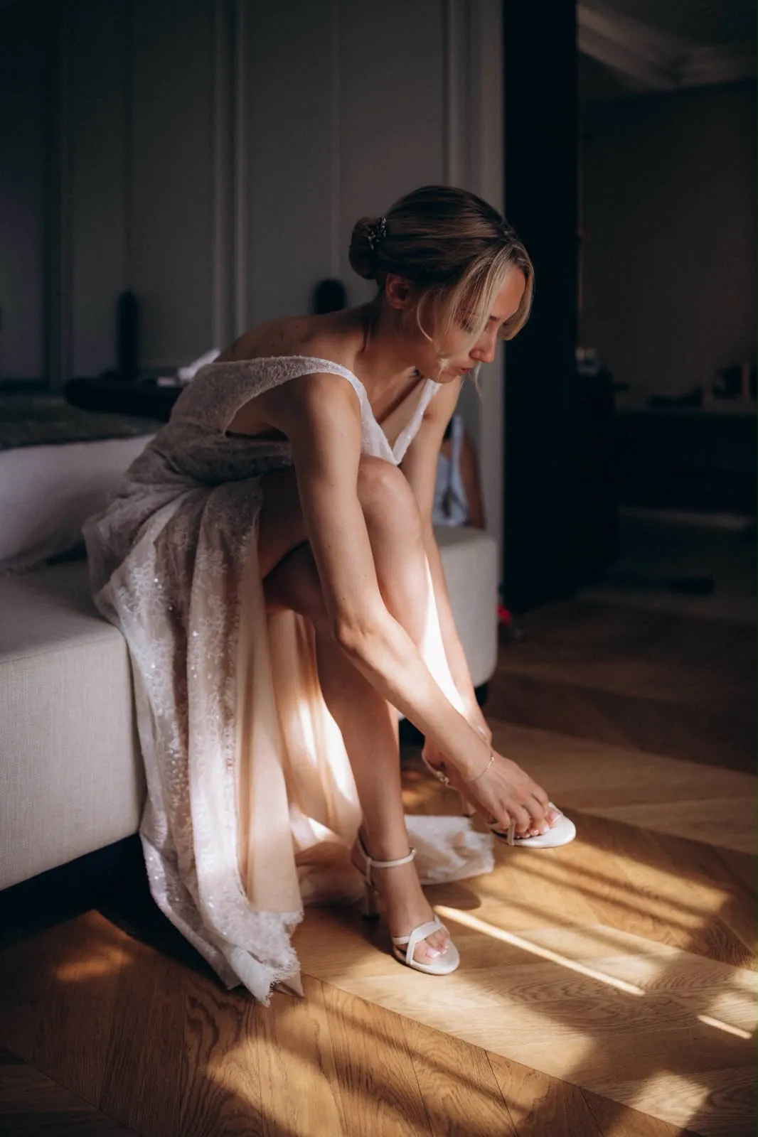 Marie, assise, attache ses chaussures dans une lumière chaude