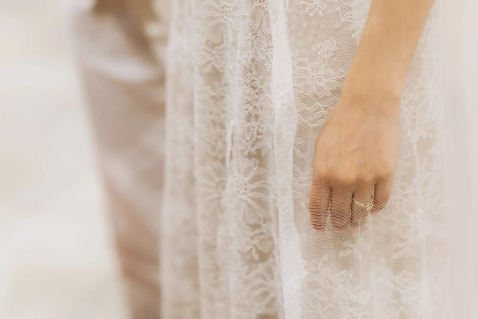 La dentelle de la robe ALBA en gros plan, et la main de Marie