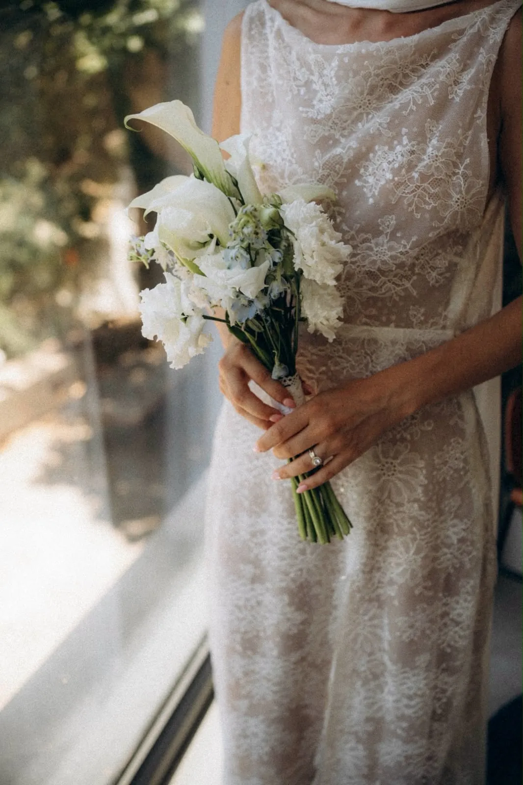 Un bouquet d'arums blancs sur la dentelle de la robe