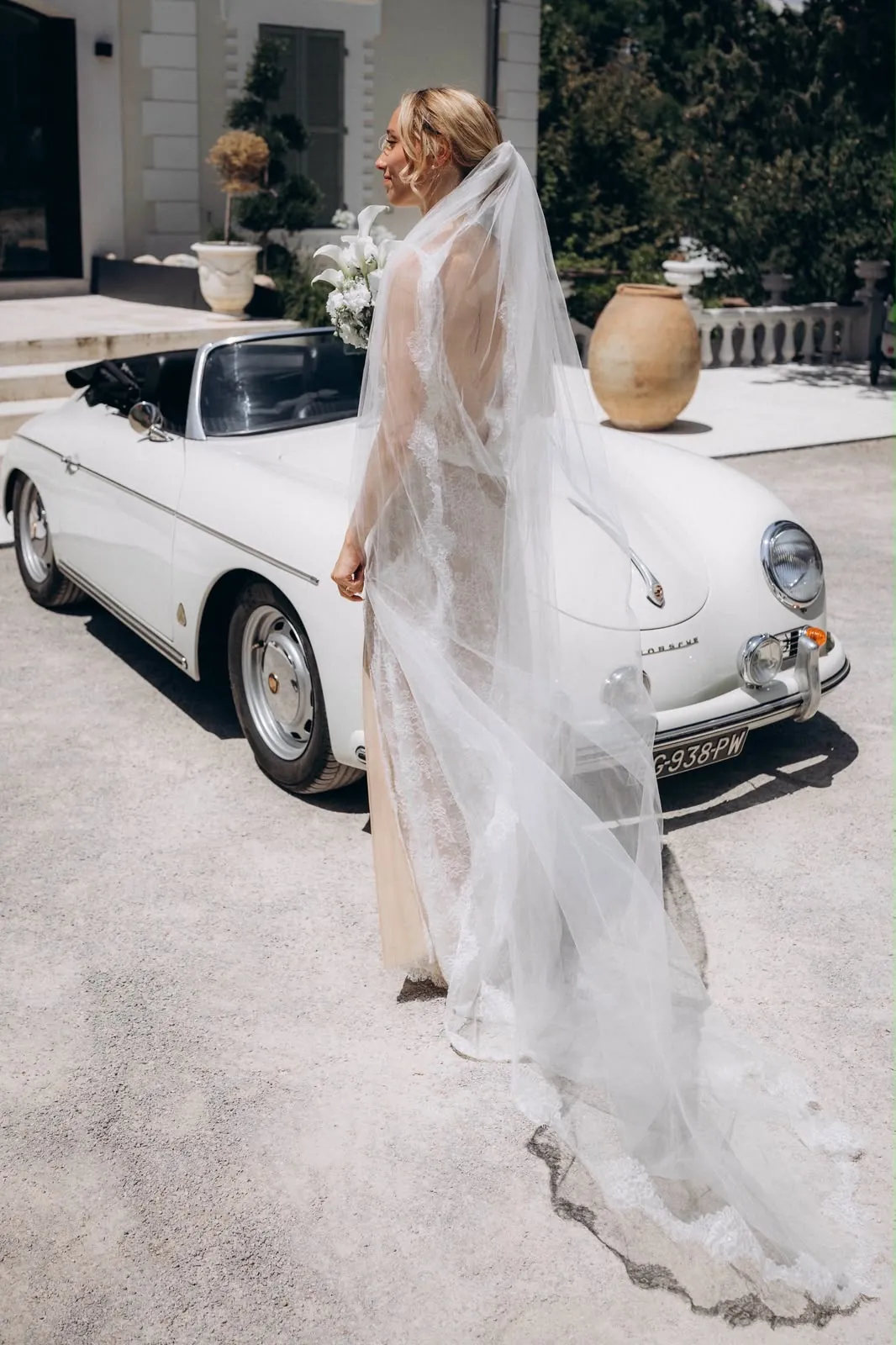 Marie et son long voile devant une voiture ancienne décapotable blanche