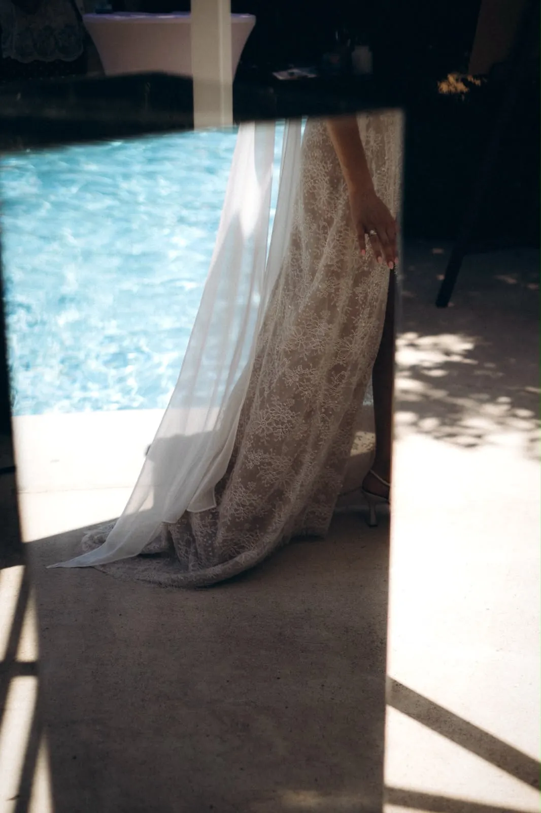 Le voile et la traîne de la robe ALBA au bord d'une piscine