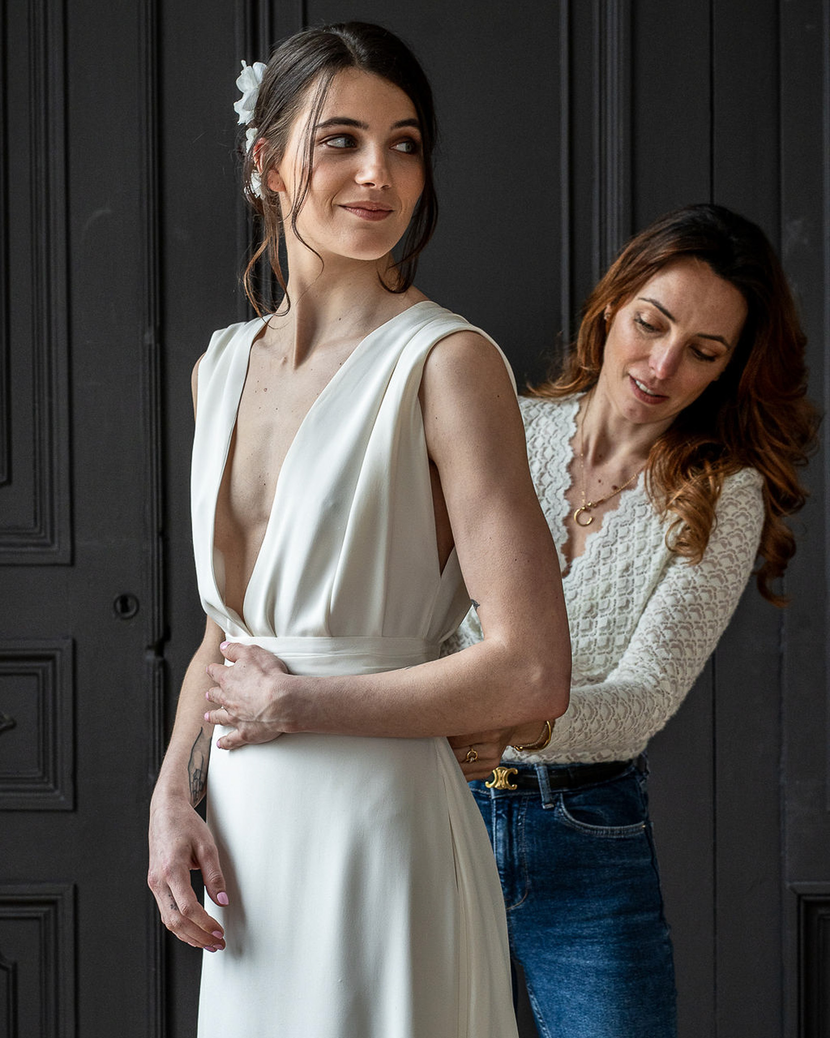 Elsa Barois ajuste une robe de mariée sur une future mariée dans le showroom de Lille